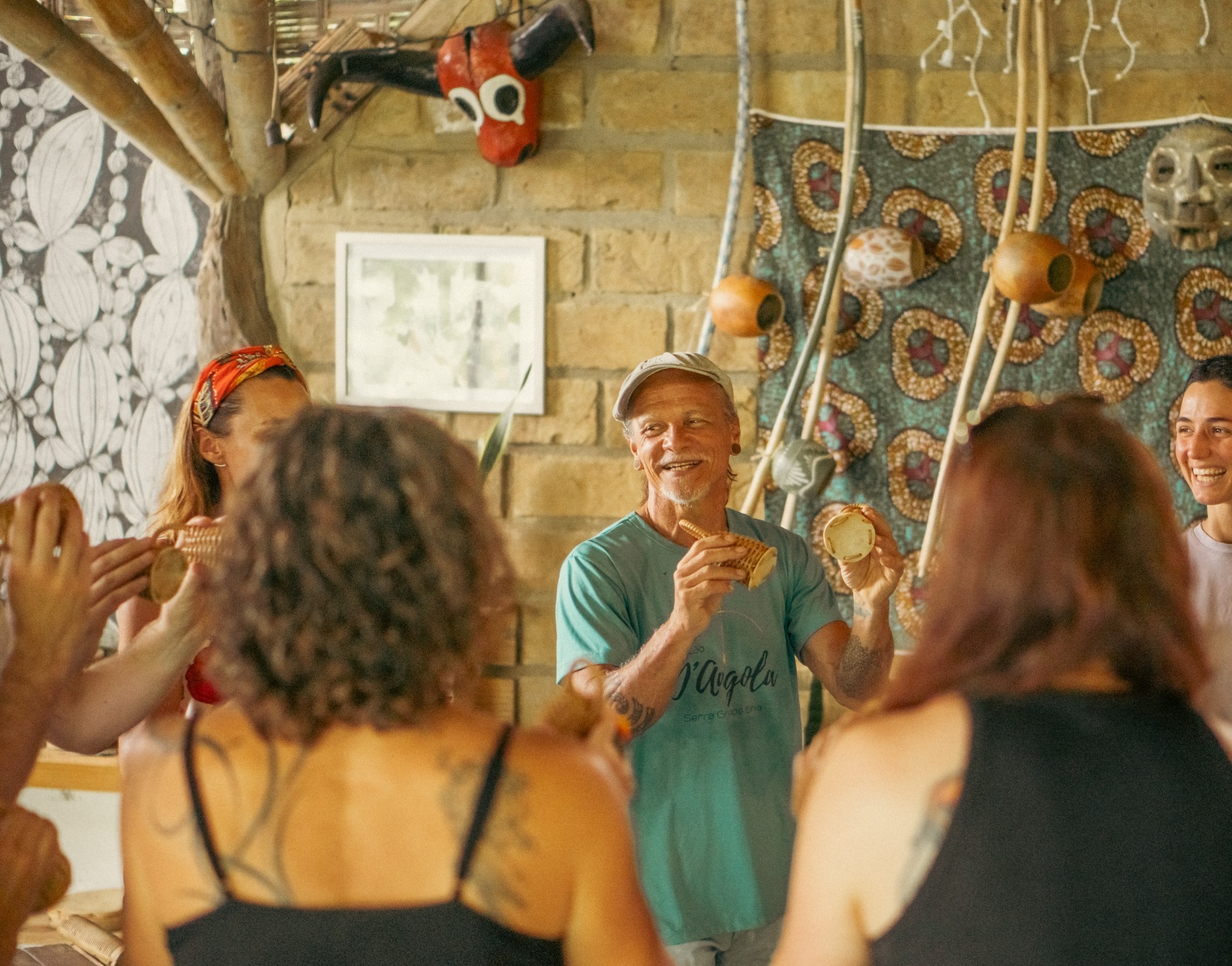Cabelo leads a rhythm and capoeira session with travellers at Barracão D’Angola in Serra Grande.